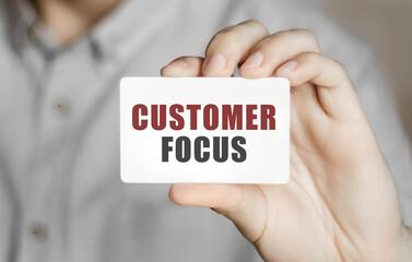 Card with text Customer focus in a man's hand