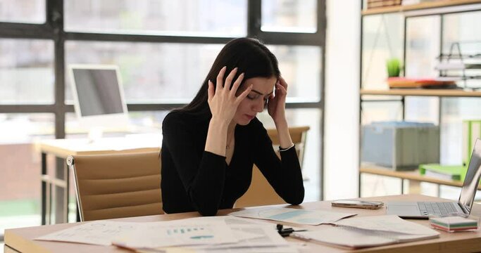 Business woman at paperwork tired and frustrated. Manager working in office looking through documents and bad financial reports