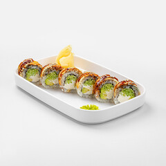 Portion of eel dragon sushi rolls with avocado and sauce