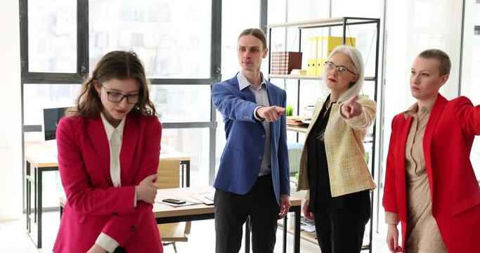 Young sad woman leaving office. Office team escorts colleague and points to exit concept
