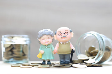 Mutual fund,Love couple senior and gold coin money in the glass bottle on white background, Save...