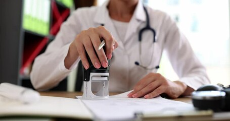 Doctor puts seal on important medical documents closeup. Registration of medical insurance