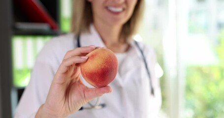 Dietitian doctor holds peach fruit in hand. Healthy diet advice and vitamin