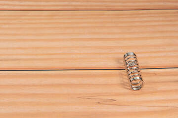 Spring or spiral spring at the edge of the image with text free space on wooden base