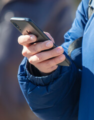 Close-up of a man's hand holding a mobile phone