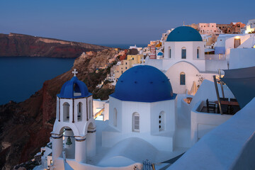 Fototapeta premium Paradise found in Santorini! This iconic image showcases the island's stunning blue domes, white houses, rugged caldera, and endless sea.