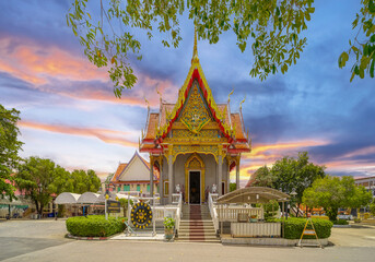 Beautiful Wat Buddhist temples in Phuket Thailand. light up at night and Decorated in beautiful ornate colours of red and Gold and Blue. Lovely sunset