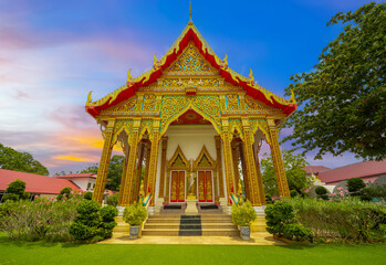 Beautiful Wat Buddhist temples in Phuket Thailand. light up at night and Decorated in beautiful ornate colours of red and Gold and Blue. Lovely sunset