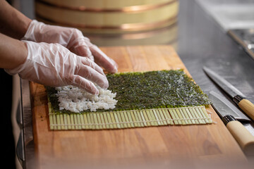 Chef cooking maki sushi rolls with rice and nori © Hihitetlin