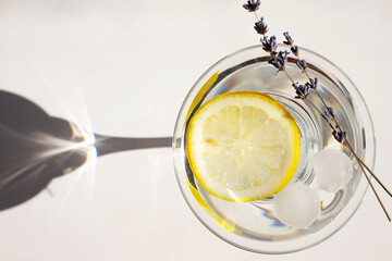A summer cocktail in the sunshine. Fresh drink in a glass with shadows on a white background.