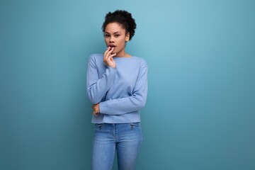 close-up of a young pensive dark-skinned woman with puffy hair in blue clothes isolated background...