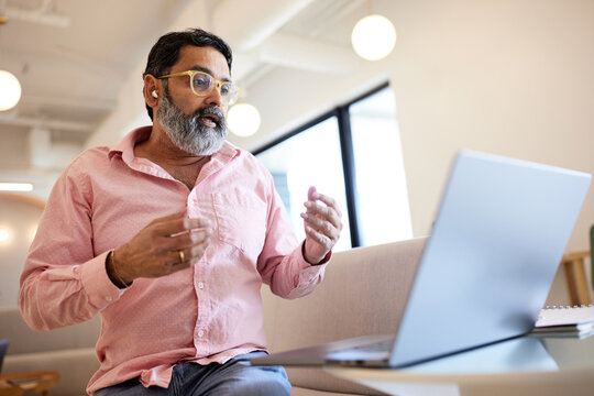 Businessman gesturing while doing video call through laptop at cafe