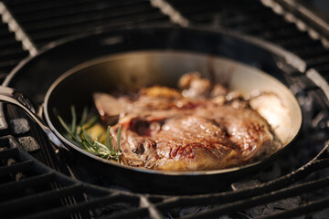 A steaming beef tenderloin steak is grilled in a grill pan. The concept of the recipe, T-bone steak. Hot coals