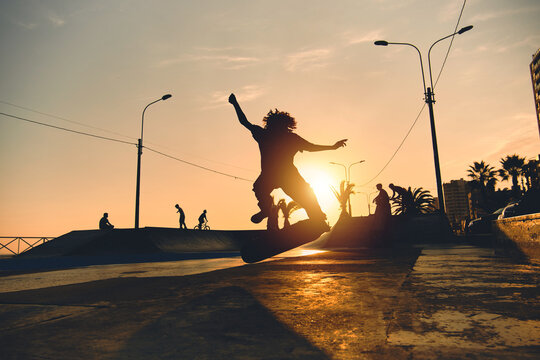 A group boys on skateboard at summer, silhouette unrecognizable.
