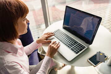 Fototapeta premium Focused young woman looking at laptop and doing research. photo is to showcase the growing trend of online education and the increasing reliance on technology for learning