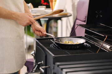 Close-up of process of seasoning carbon steel pan. Classic France frying pan. Outdoor grill