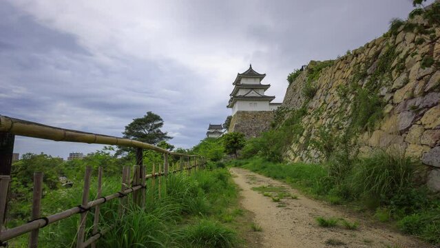 Time Lapse: Clouds move over path to historic Akashi Castle on windy day