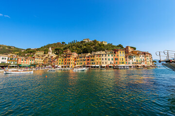 Fototapeta na wymiar Cityscape and port of Portofino, luxury tourist resort in Genoa Province, Liguria, Italy, Europe. Colorful houses, Mediterranean sea (Ligurian sea).