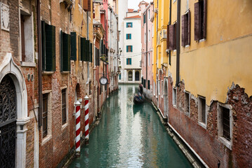 Fototapeta na wymiar Narrow canal with gondolas in Venice, Italy