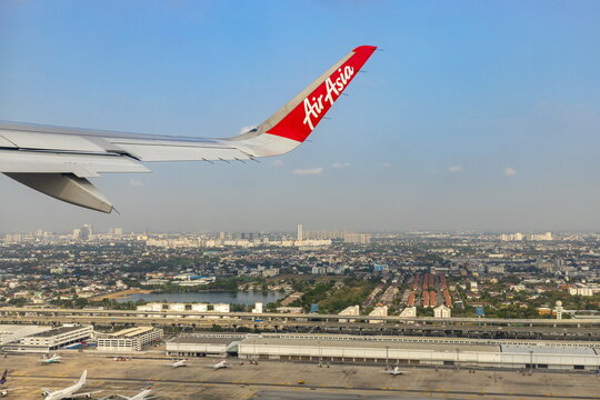 Bangkok Thailand - March 28, 2019: AirAsia (a popular low-cost airline)'s aircraft wing just took off from Don Mueang Airport. The ground image shows the city of Bangkok, the capital of Thailand.