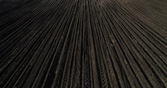 Drone shot of a fertile arable agricultural industrial farm field. Aerial view of a plowed agricultural field
