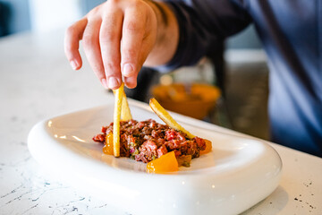 Crop person serving steak tartare