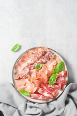 Cured Meat Platter, Antipasto Set, Appetizer Variety on Plate over Concrete Background