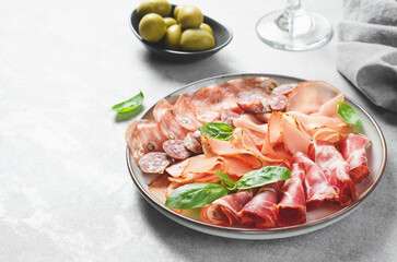 Cured Meat Platter, Antipasto Set, Appetizer Variety on Plate over Concrete Background