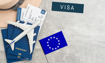 Flag of European Union with passport and toy airplane on wooden background. Flight travel concept