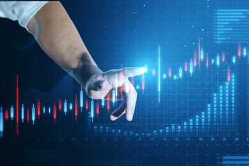 Close up of businessman hand pointing at abstract glowing candlestick business chart on blue...