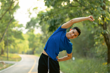 Fototapeta premium Sporty man stretching his muscular before before running in the morning. Fitness, sport and healthy lifestyle concept