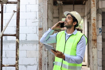 Technician civil engineer or specialist inspector discussing, brainstorm and planing real estate project work with smart mobile phone and blueprint at Industrial building site. Construction concept