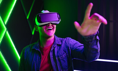 Young man playing an exciting virtual reality game with Vr goggles