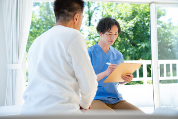 カウンセリングする介護士と話を聞く日本人シニア男性