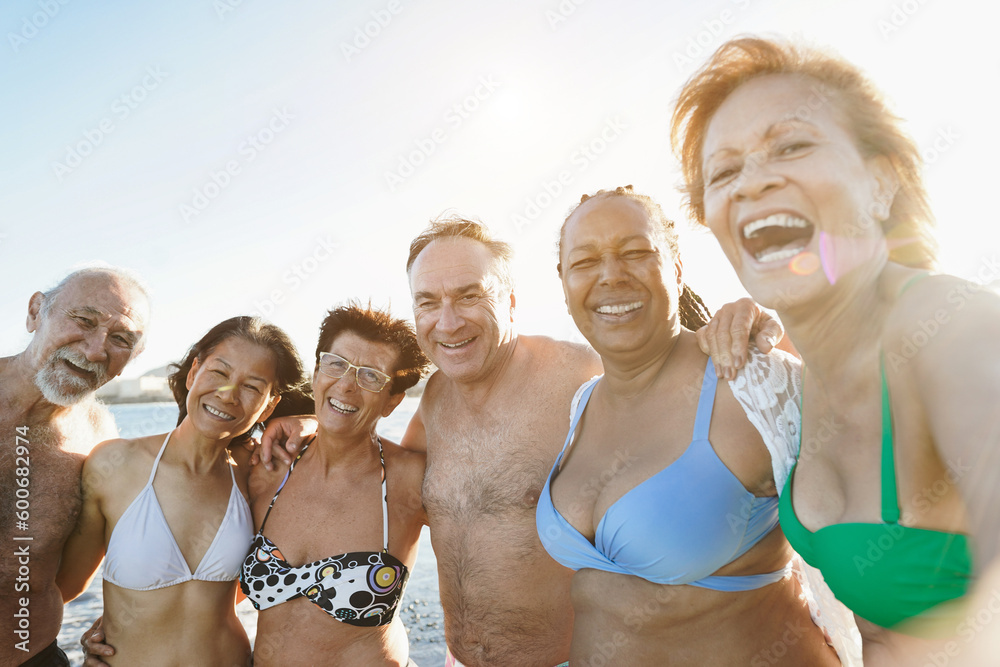 Wall mural multiracial senior people taking selfie on the beach during summer vacation - joyful elderly lifesty