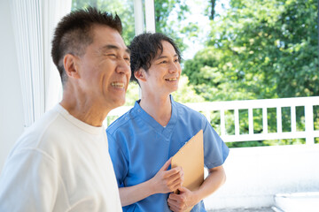 カウンセリングする介護士と話を聞く日本人シニア男性