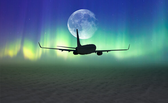 Passenger airplane in the sky against blue full moon and aurora borealis "Elements of this image furnished by NASA "