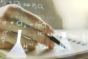 Creative chemistry hologram with man hand writing in notepad on background, pharmaceutical research concept. Multiexposure