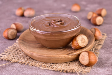 Delicious chocolate spread with hazelnut flavor on a gray background.
