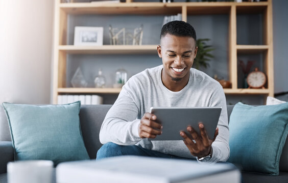 Smile, tablet and man on sofa on social media meme, email or streaming video on subscription service. Happiness, internet and networking, happy male surfing online and movie website on couch in home.