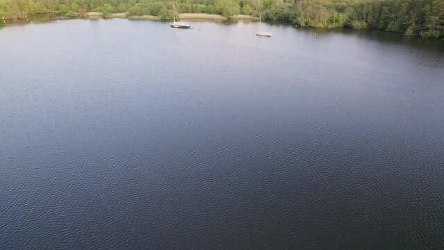 Aerial footage of Wroxham Broad, a quiet and scenic body of water in the Norfolk Broads national park. Captured on a bright evening just before the sun started to set