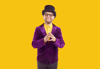 Happy smiling young man dressed in retro style. Portrait of handsome young man in glasses wearing purple velvet jacket and top hat. Conjurer, announcer, showman, presenter or illusionist