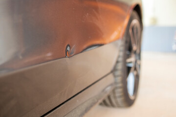 Car dent after traffic accident or crash.Deformity lesion on the rear door of grey vehicle with...