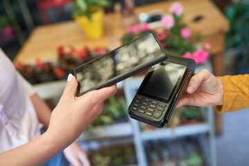 Customer pays contactless with mobile phone at the NFC reader