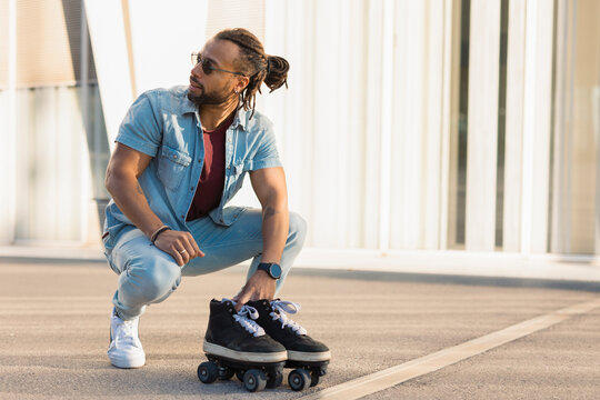 Urban modern man enjoy outside. Fashion man posing with roller skates.