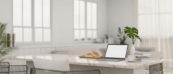 A laptop mockup on a white marble dining table in modern white living room