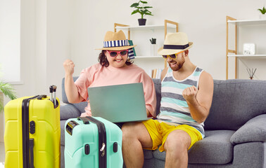 Funny family couple booking cheap airline tickets to travel to their holiday destination. Happy man...