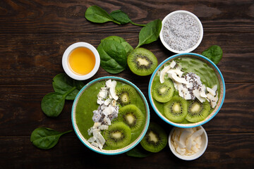 Green Smoothie Bowl with Spinach, Banana, Chia Seeds on Brown Background