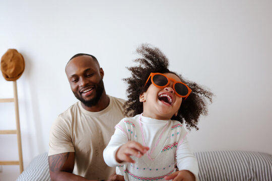 Happy caring African American family young dad father and small cute child daughter portrait, loving black dad and little mixed race kid girl bonding on fathers day
