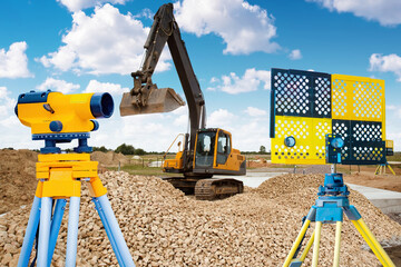 Construction work. Geodetic equipment. Excavator and total station. Geodetic instruments for...